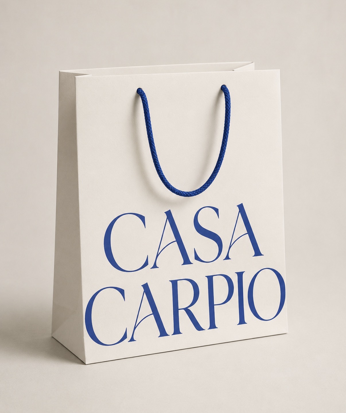Casa Carpio cream shopping bag with blue serif wordmark
