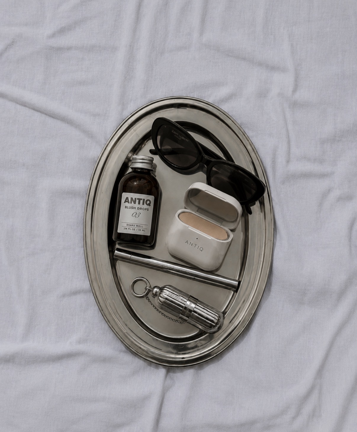 Antiq blush drops and compact on a silver tray