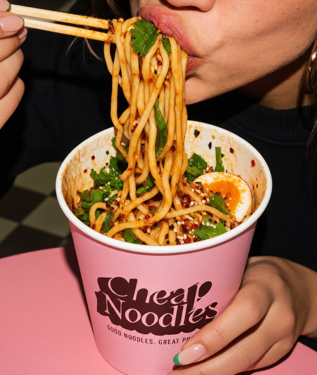 Person eating noodles straight from a Cheap Noodles cup