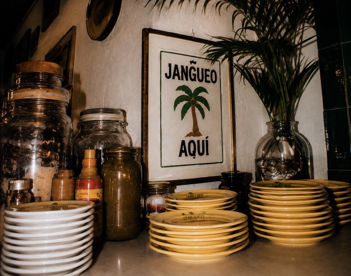 Jangueo aqui framed palm sign above stacked plates