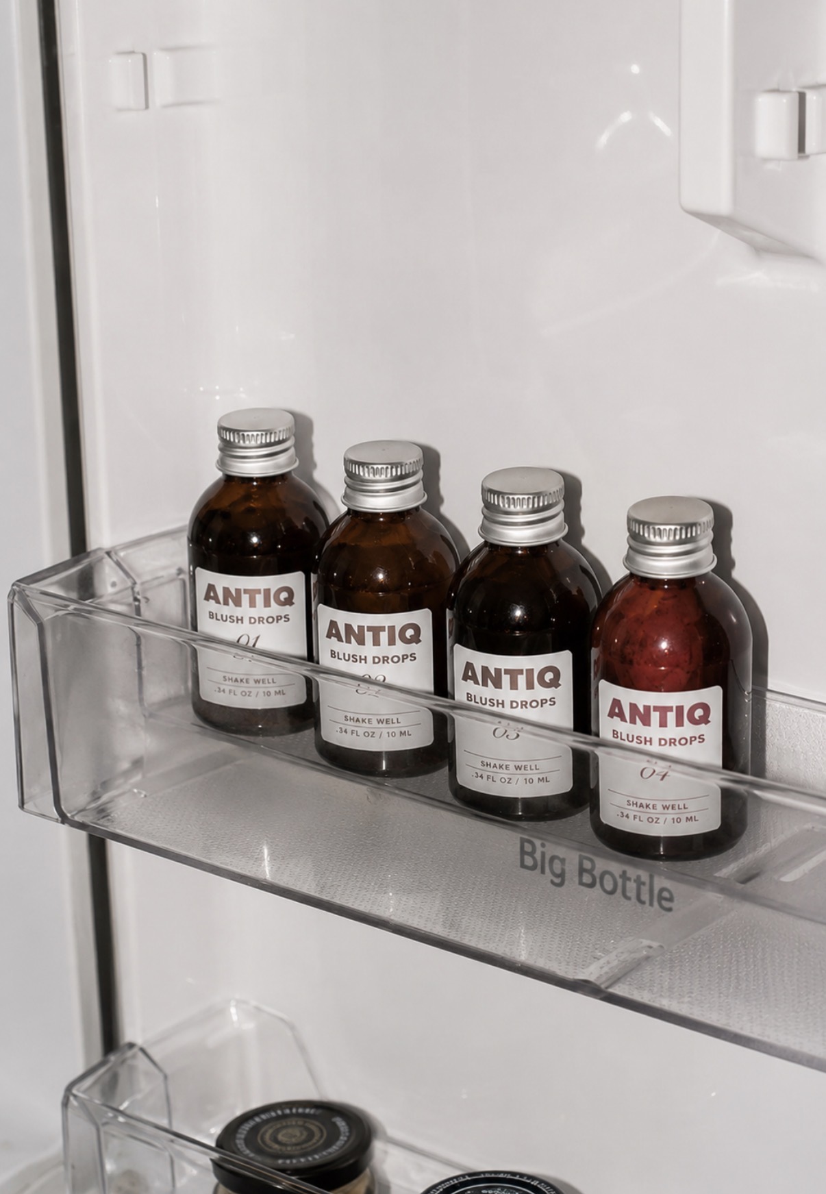 Antiq blush drops lined up in a fridge door