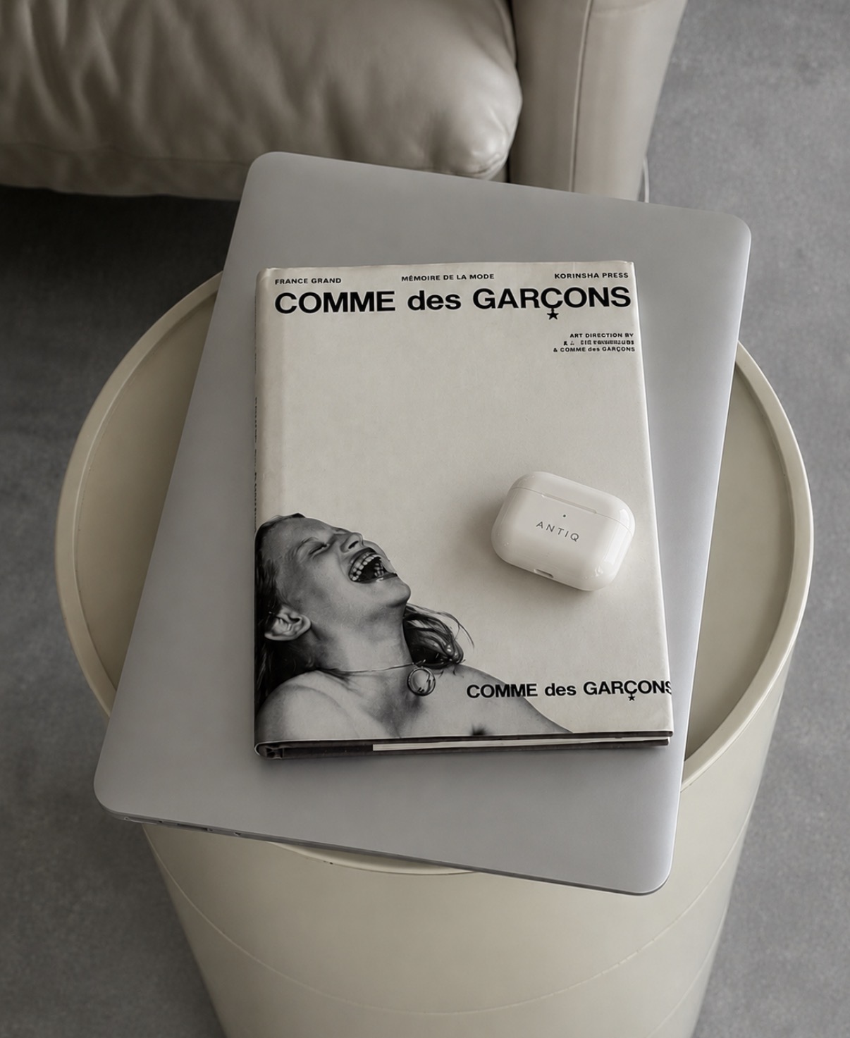 Antiq compact on a Comme des Garçons book